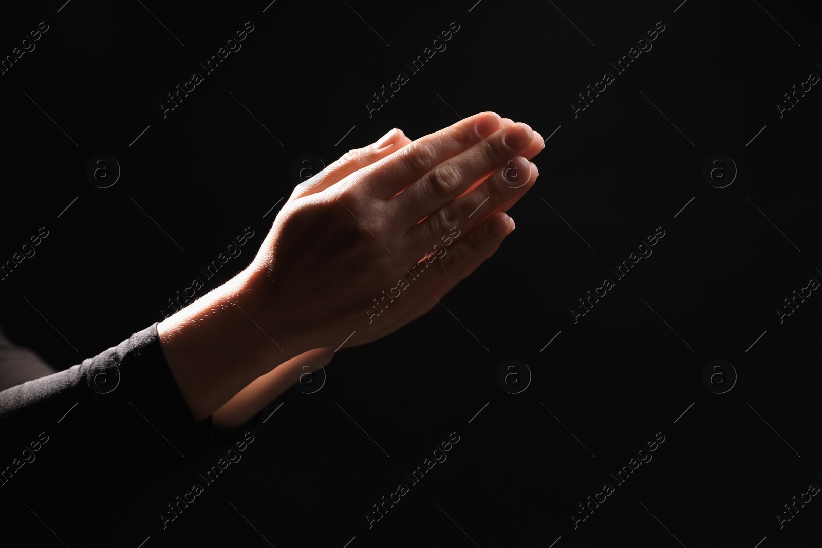 Photo of Religion. Christian woman praying on black background, closeup. Space for text