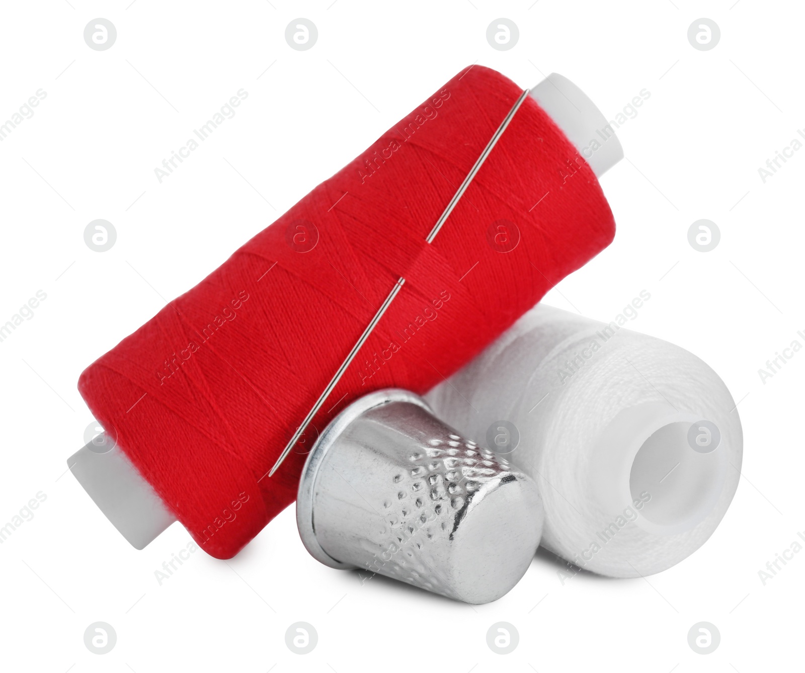 Photo of Thimble and spools of sewing threads with needle isolated on white