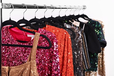 Photo of Collection of different beautiful women's party dresses on hangers in showroom. Stylish trendy clothes for high school prom