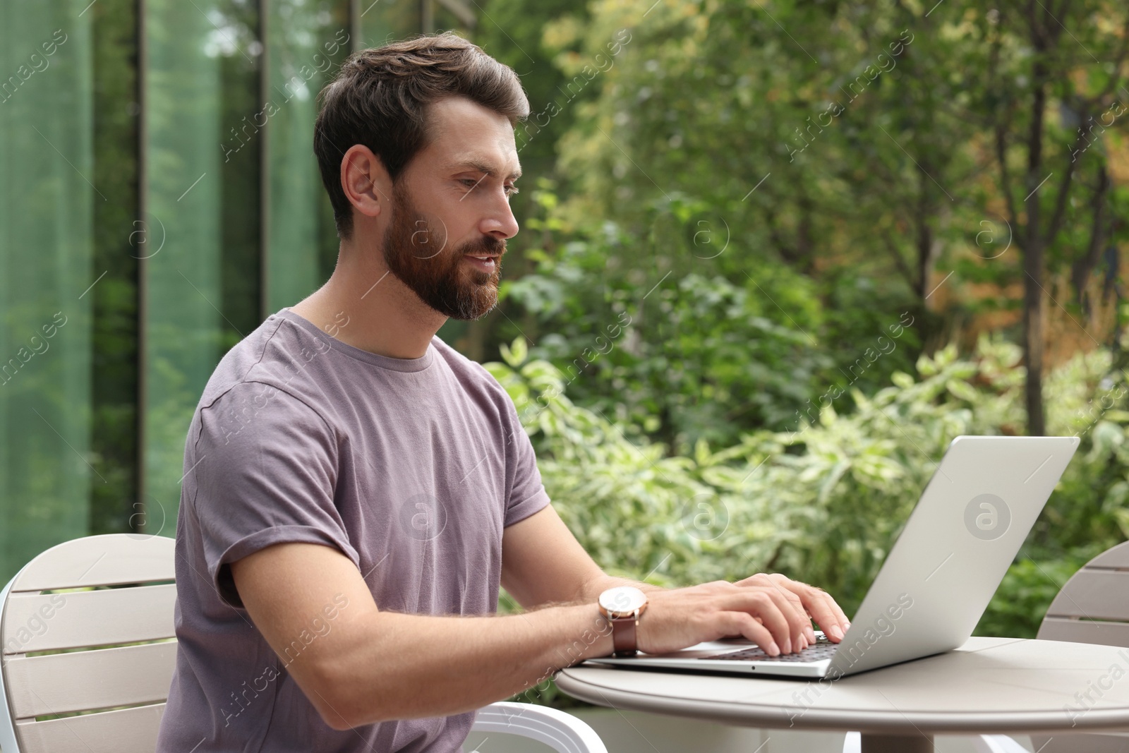 Photo of Handsome man with laptop in outdoor cafe