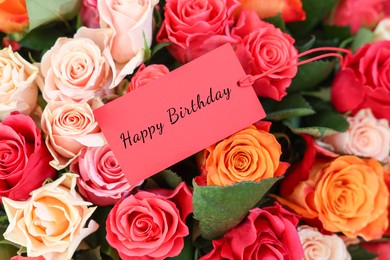 Image of Bouquet of beautiful roses with Happy Birthday card, top view