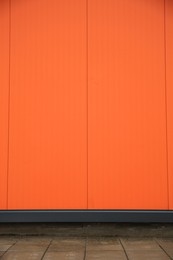 Photo of Beautiful orange wall and stone pavement outdoors