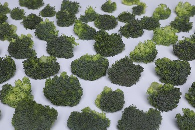 Many fresh green broccoli pieces on white background, closeup