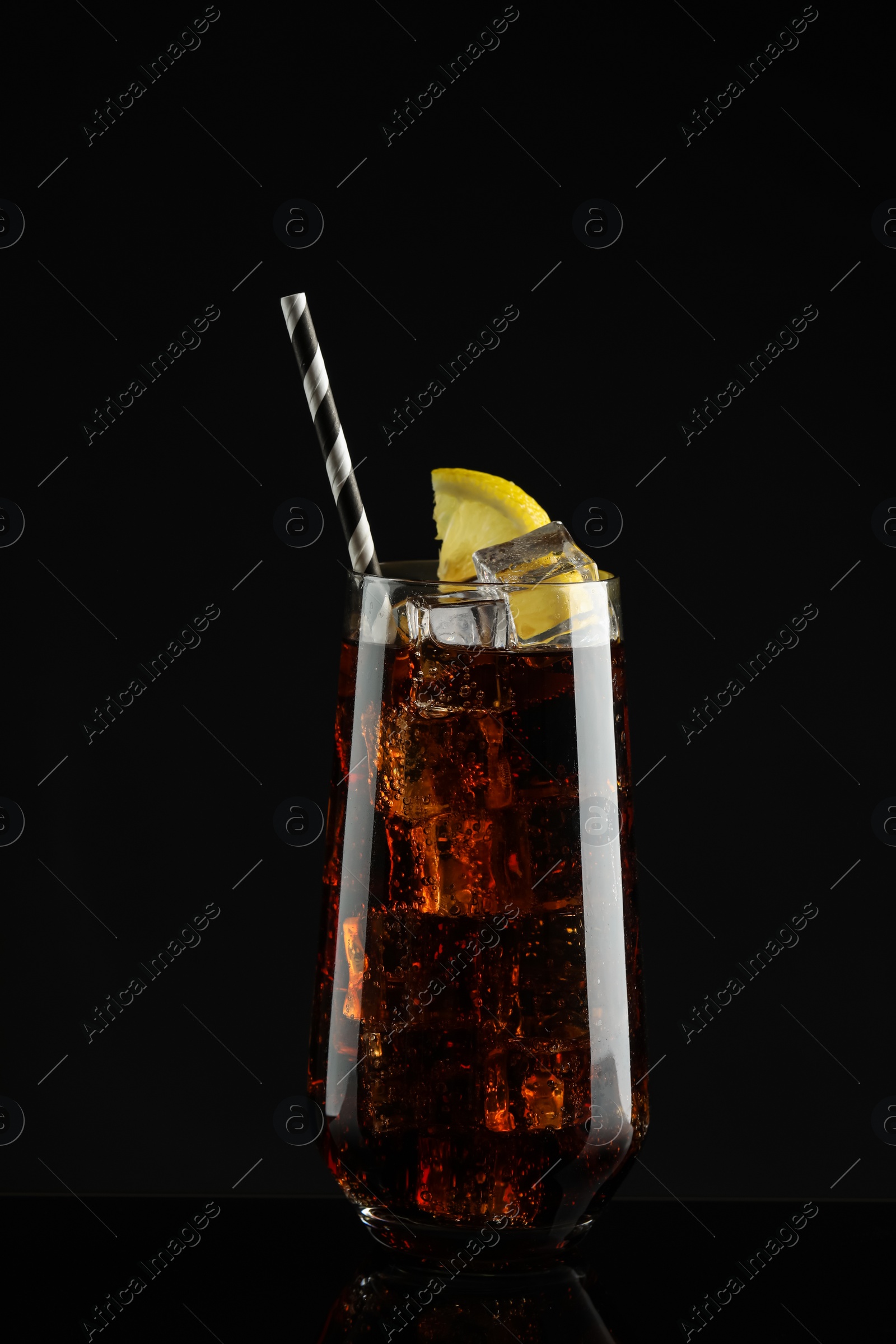 Photo of Glass of refreshing soda water with ice cubes and lemon slice on black background