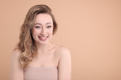 Portrait of smiling woman on beige background. Space for text