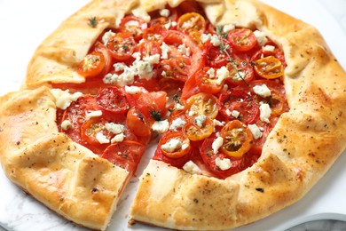 Tasty galette with tomato, thyme and cheese (Caprese galette) on white table, closeup