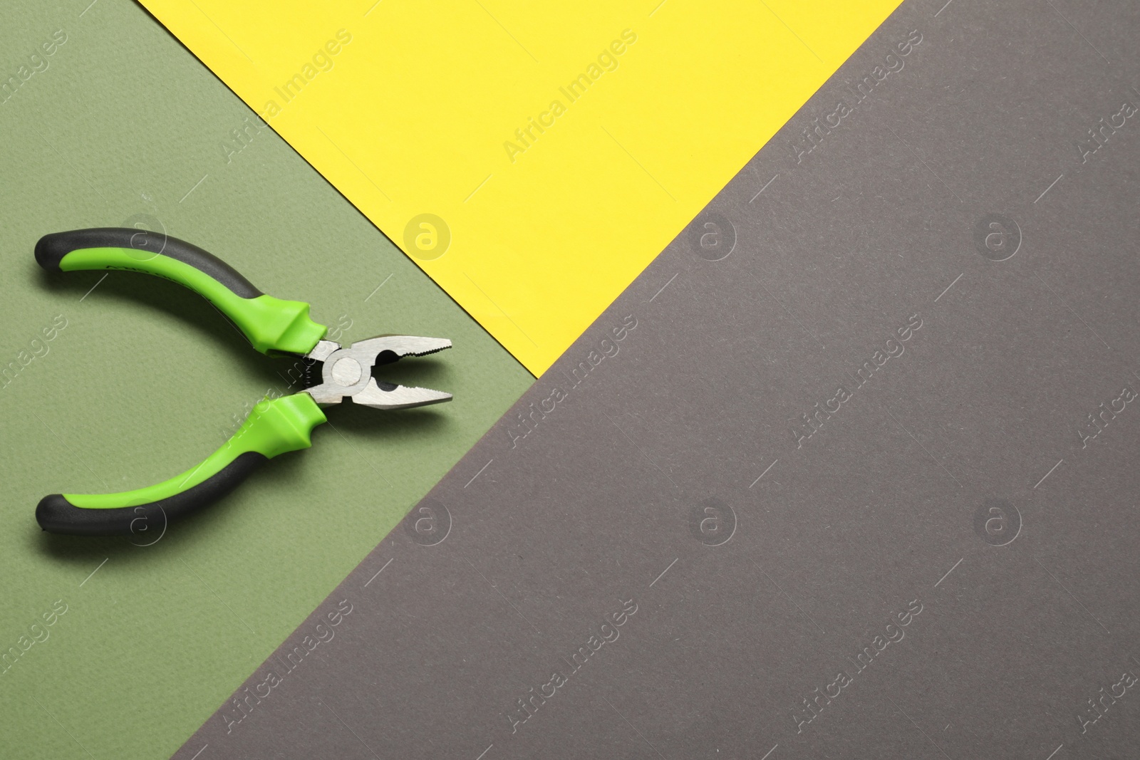 Photo of Combination pliers on color background, top view. Space for text