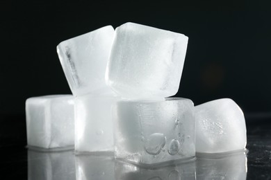 Photo of Crystal clear ice cubes on dark grey background, closeup