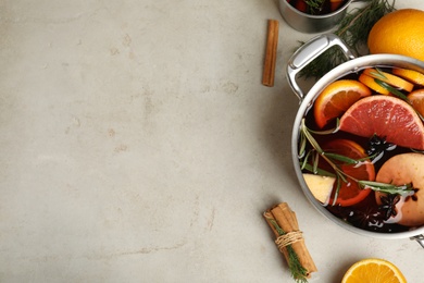 Photo of Tasty mulled wine with spices on light grey table, flat lay. Space for text