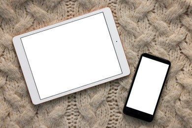 Photo of Modern tablet and smartphone on beige fabric, top view. Space for text