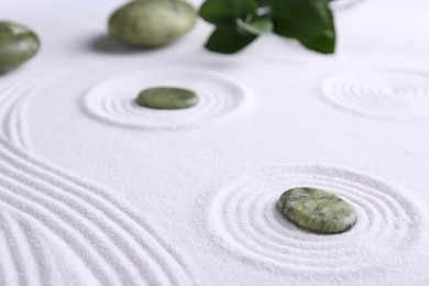 Photo of Zen concept. Stones, leaves and pattern on white sand, closeup