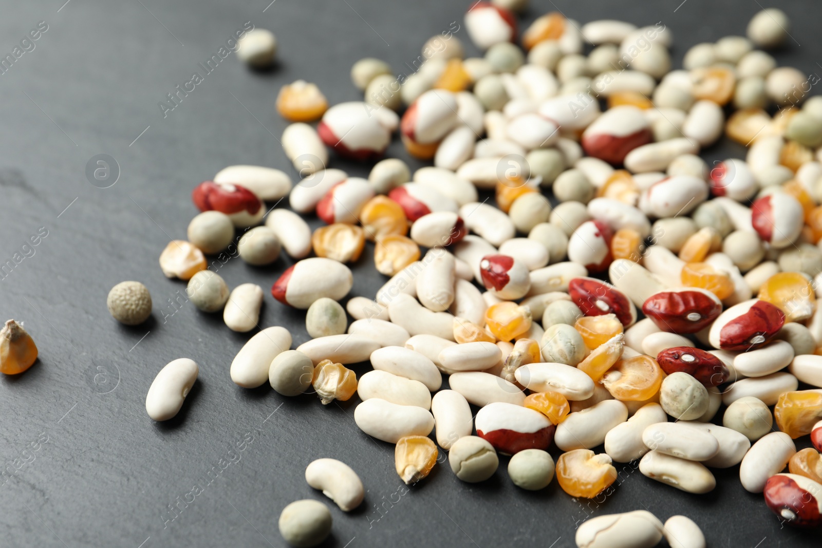 Photo of Mixed vegetable seeds on grey background, closeup