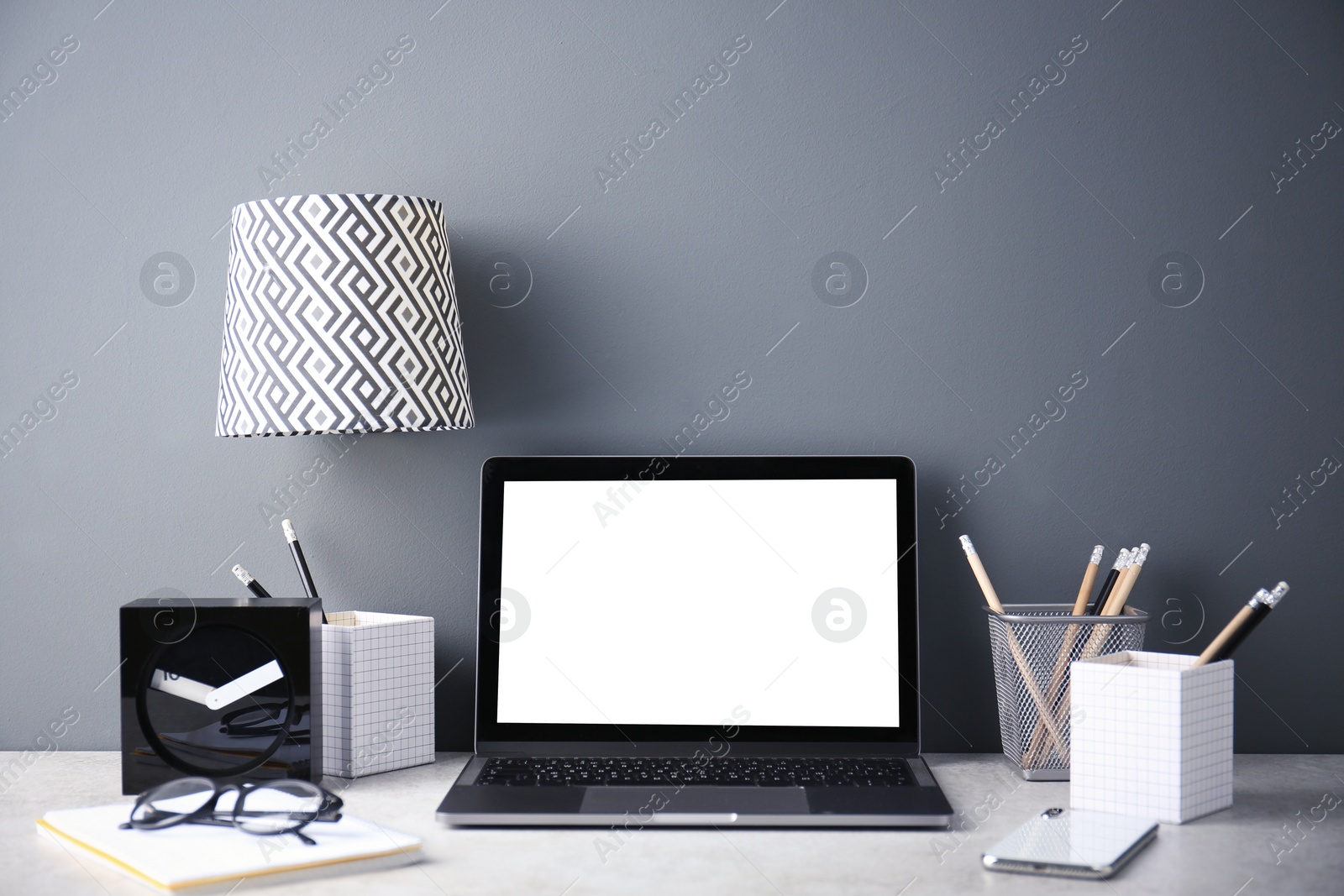 Photo of Modern workplace with laptop on table. Blank screen for mockup