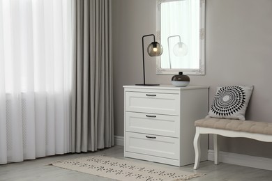 Photo of Hallway with stylish chest of drawers and mirror. Interior design