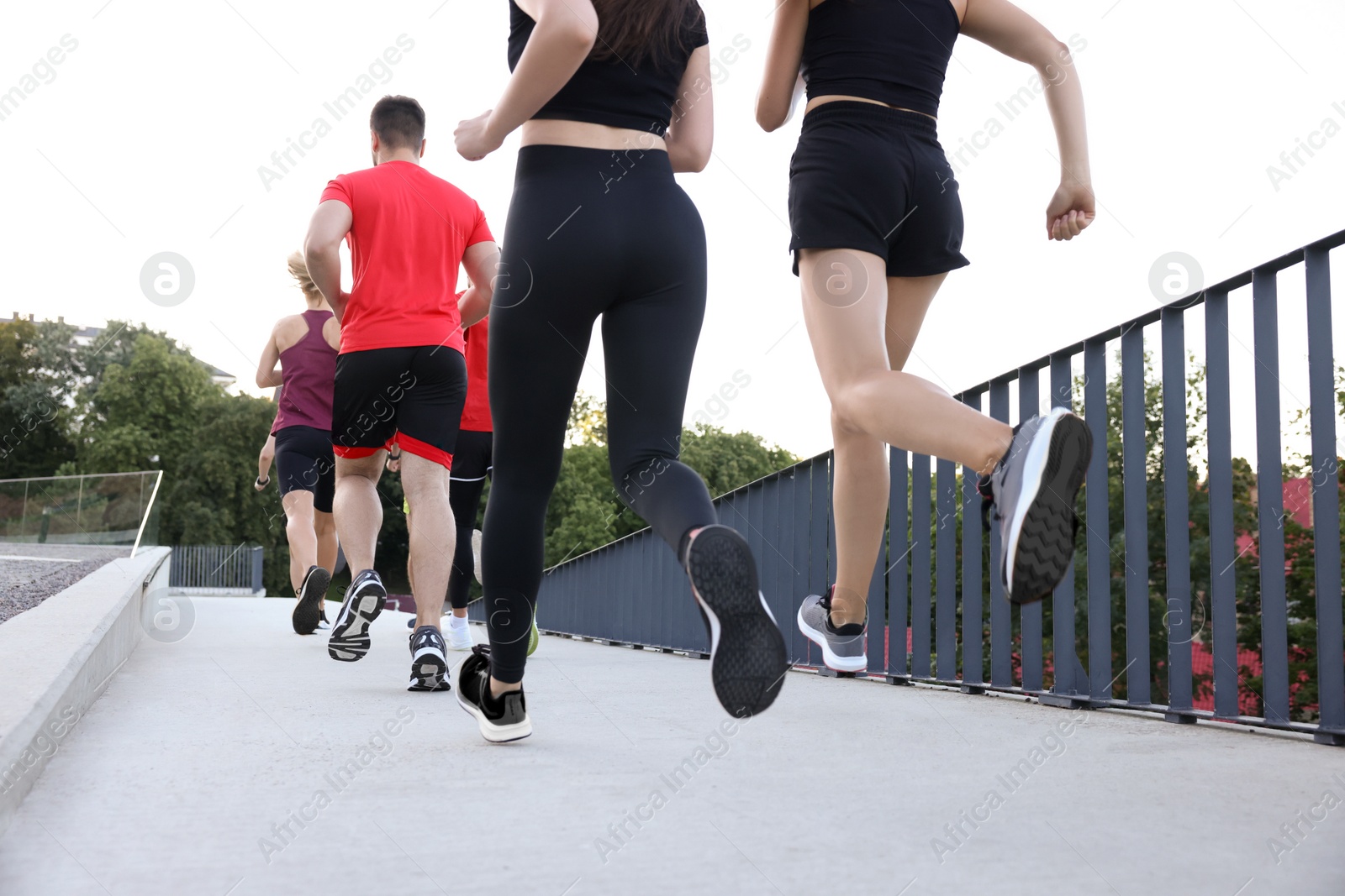 Photo of Group of people running outdoors, back view