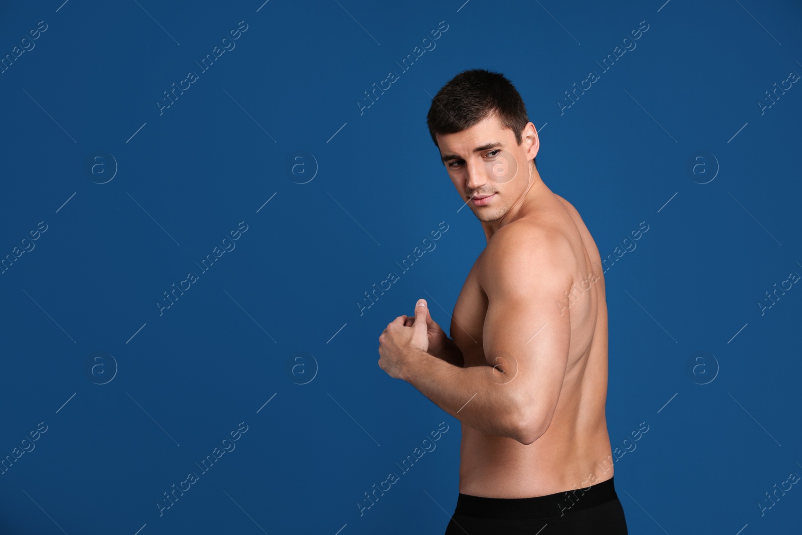 Photo of Man with sexy body on blue background. Space for text