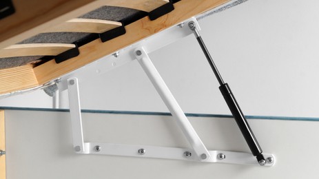 Closeup view of lifting mechanism for opening under bed storage