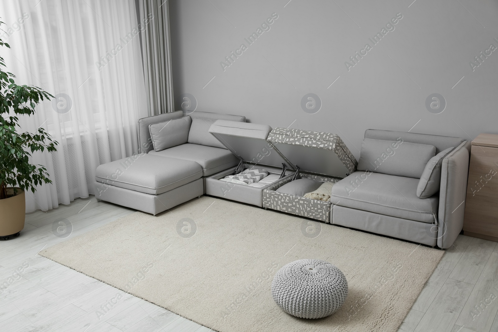Photo of Modular sofa with storage near wall in living room. Interior design