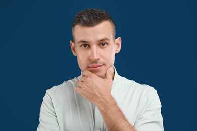 Photo of Portrait of handsome man on blue background