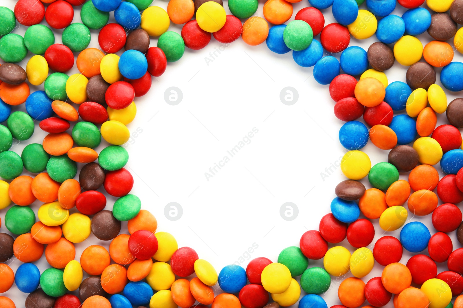 Photo of Frame made of colorful candies on white background, top view. Space for text