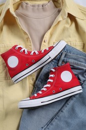 Photo of Pair of stylish red sneakers and clothes, flat lay