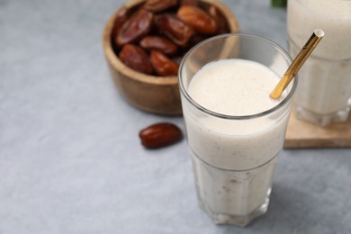 Photo of Glass of delicious date smoothie and dried fruits on light grey table, closeup. Space for text