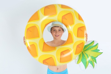 Photo of Cute little child in beachwear with bright inflatable ring on white background