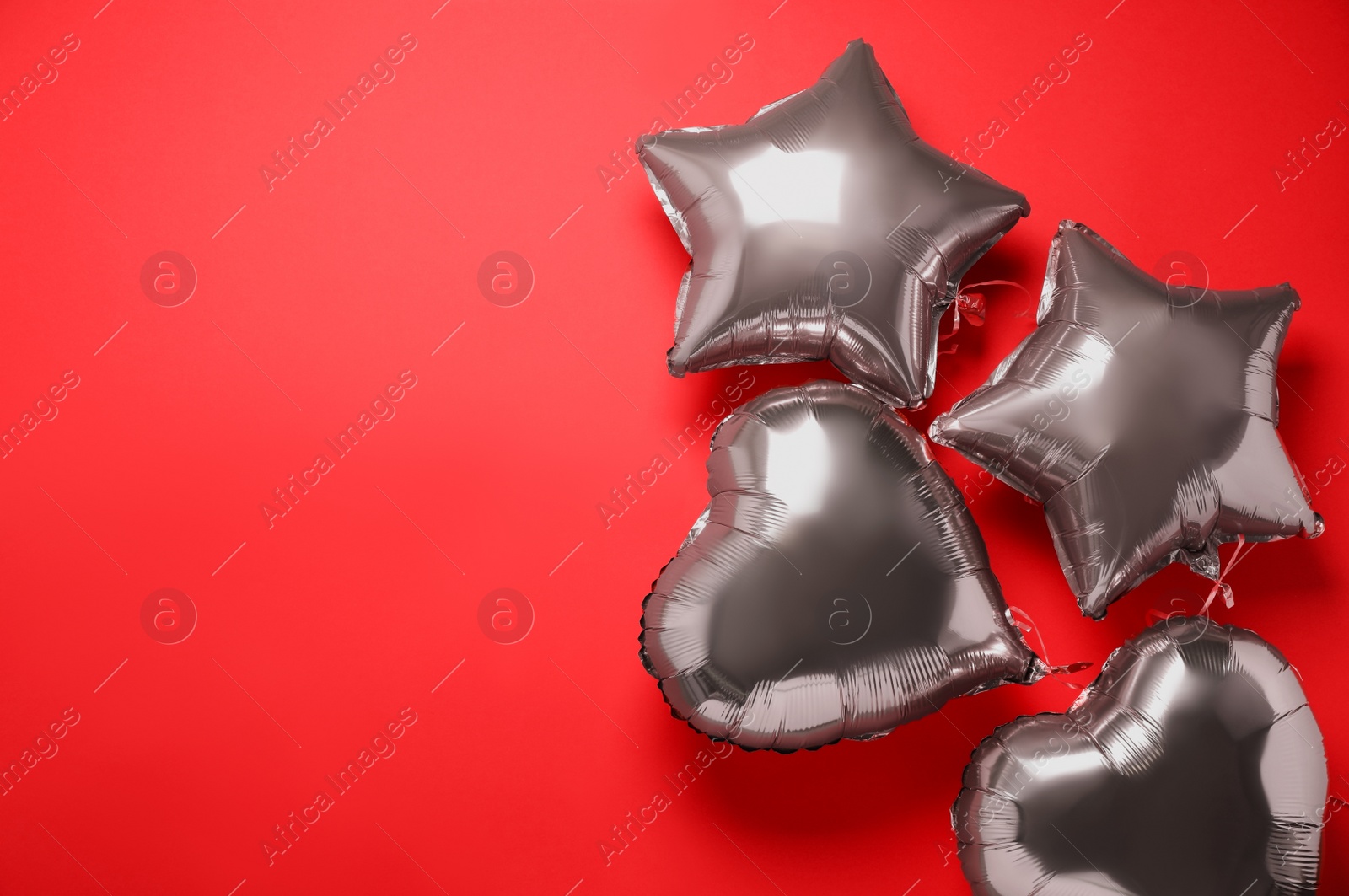 Photo of Colorful balloons on red background, flat lay. Space for text