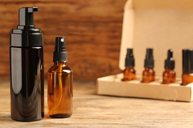 Photo of Bottles with oil on wooden table, space for text. Natural cosmetics