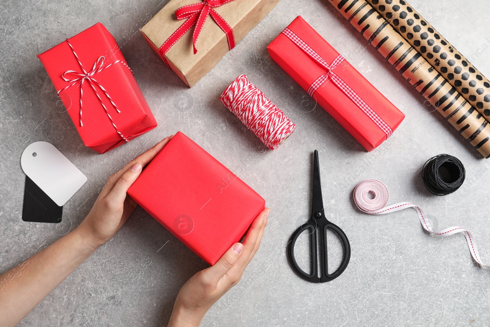 Photo of Woman wrapping gift box at table, top view