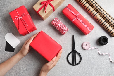 Photo of Woman wrapping gift box at table, top view