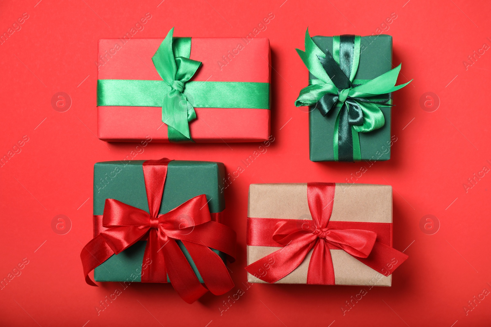 Photo of Elegant gift boxes with bows on red background, flat lay
