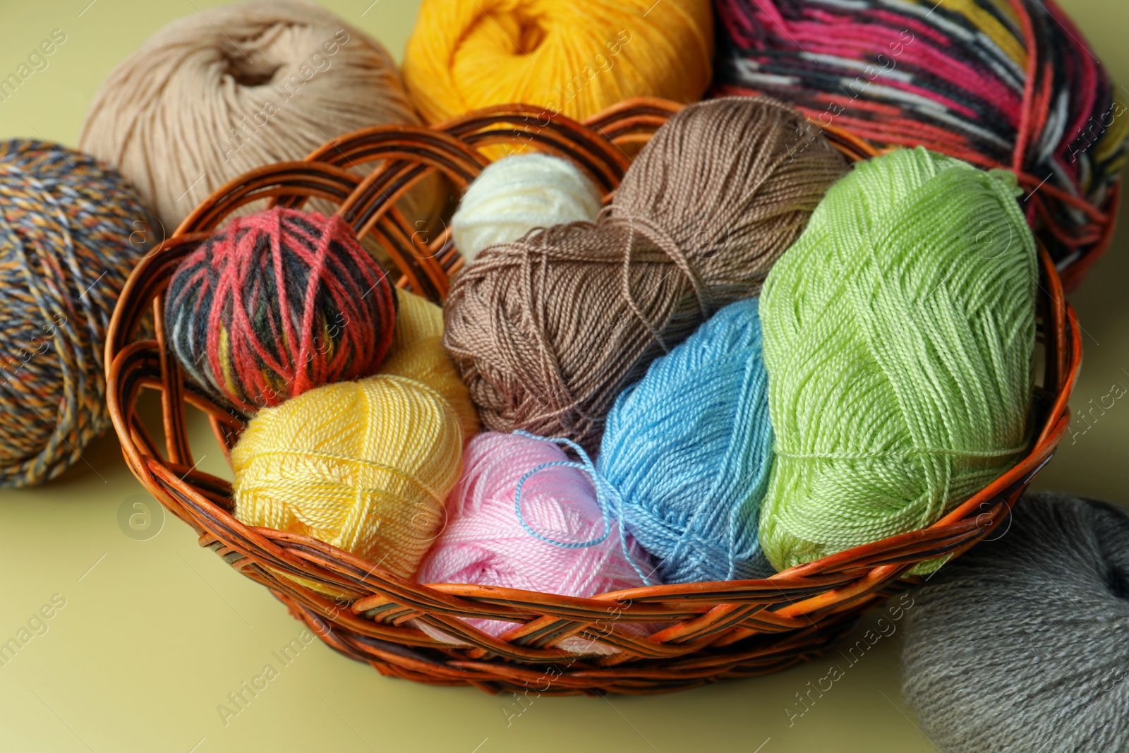 Photo of Many different soft woolen yarns on yellow background