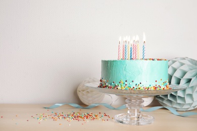 Photo of Stand with fresh delicious cake and birthday decorations on table. Space for text