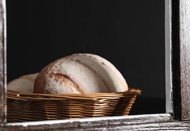 Photo of Fresh homemade bread in wicker basket, view through window