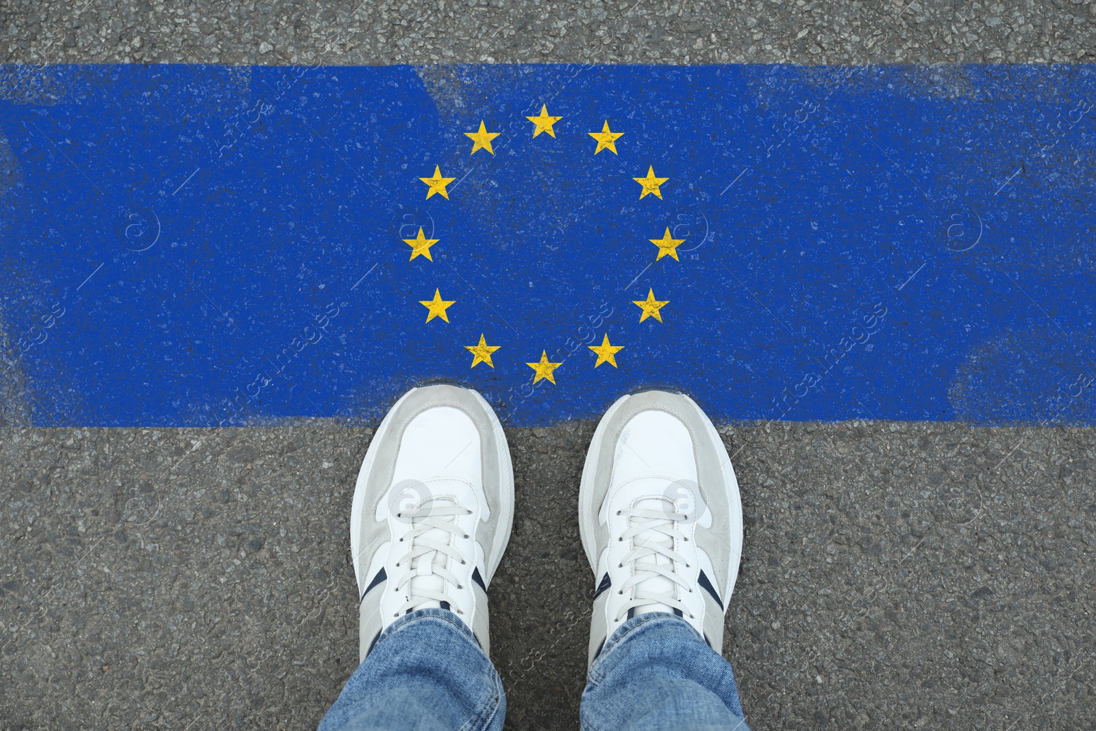 Image of Immigration. Man standing on asphalt near flag of European Union, top view