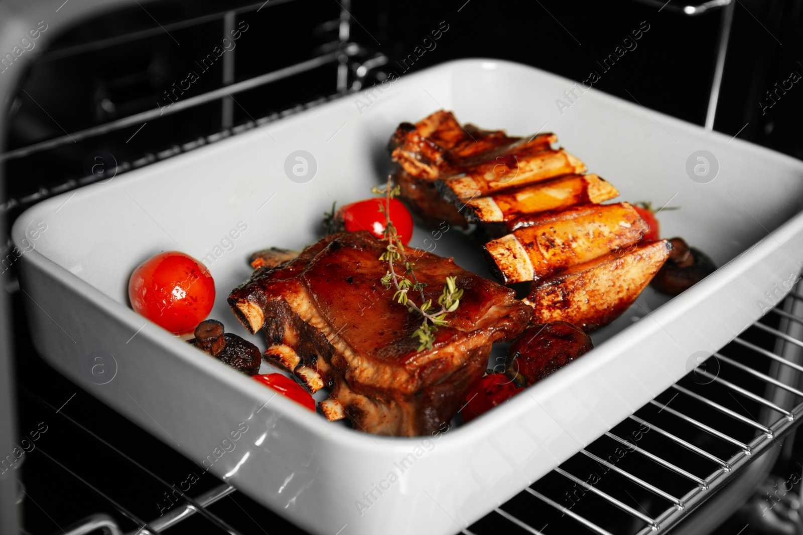 Photo of Delicious roasted ribs in oven, closeup. Yummy meat