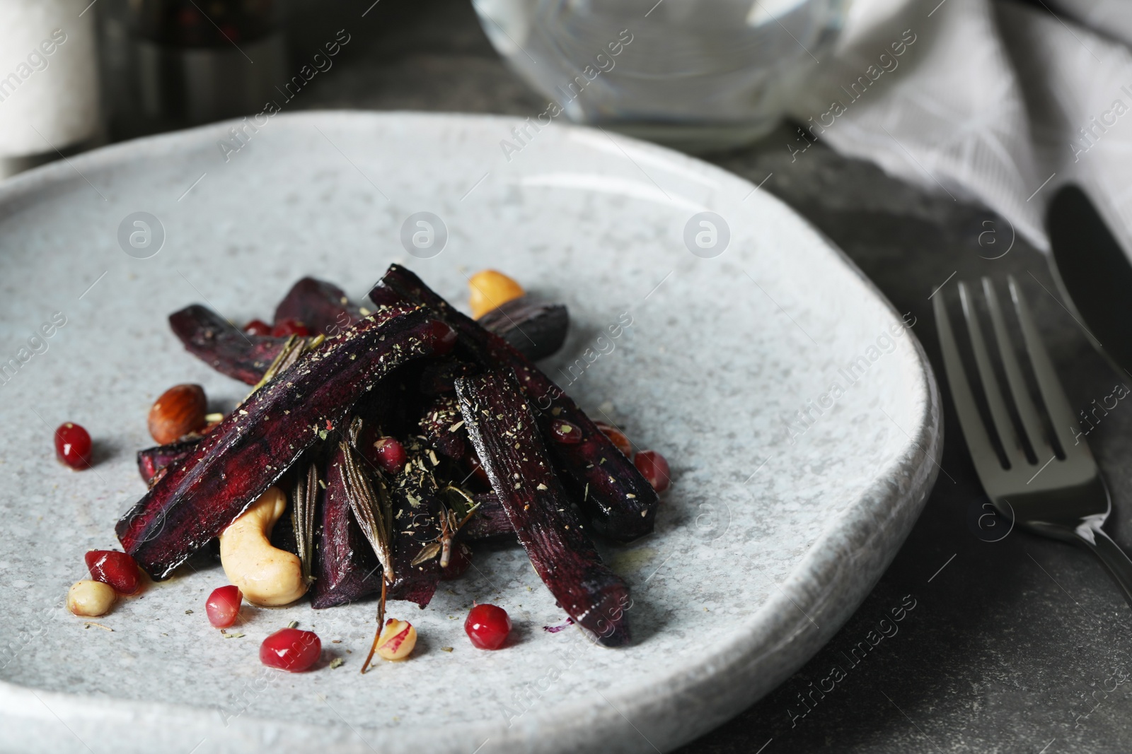 Photo of Tasty baked black carrot on table, closeup