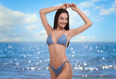 Happy woman in stylish bikini near sea