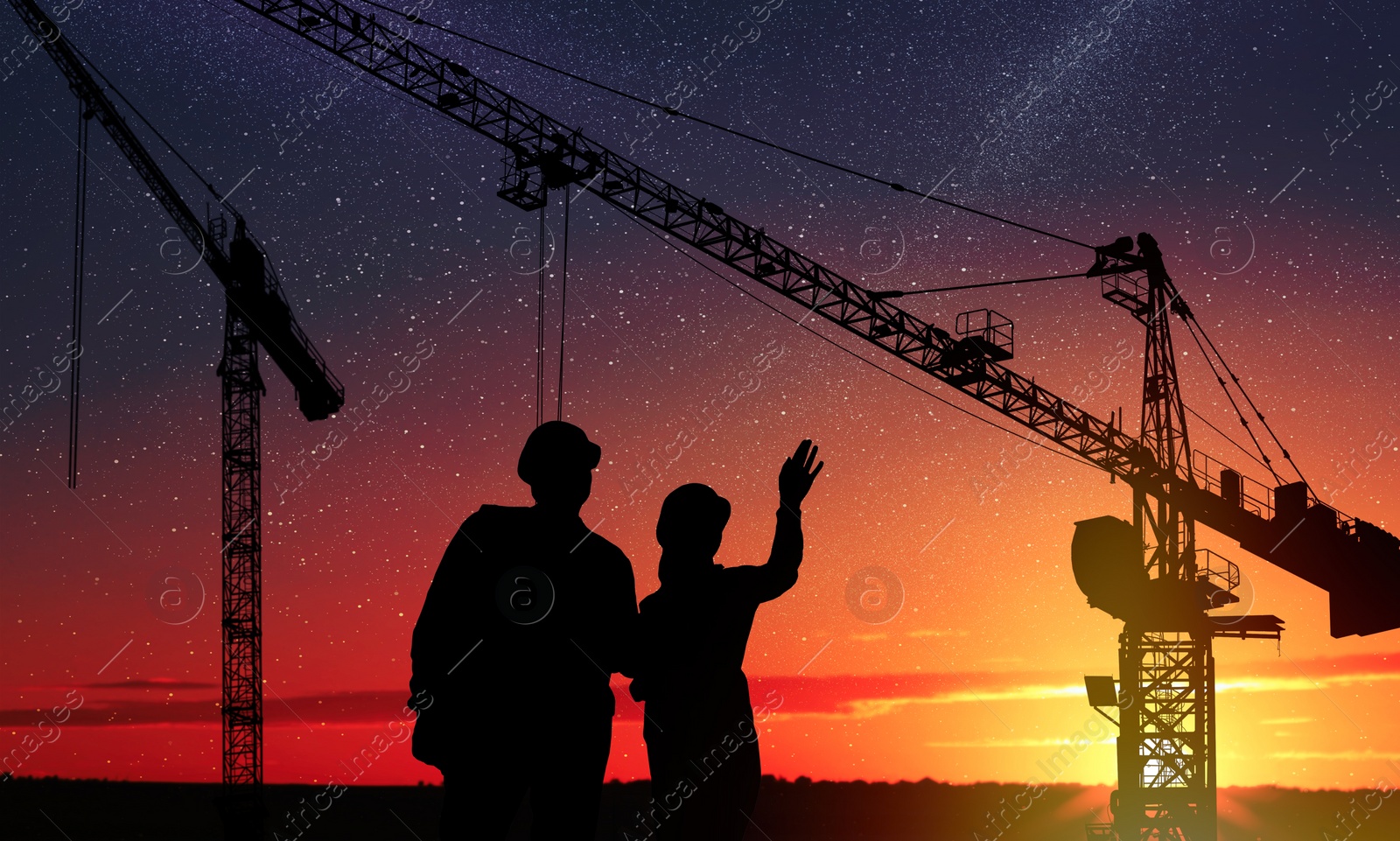 Image of Silhouettes of engineers near construction site at sunrise