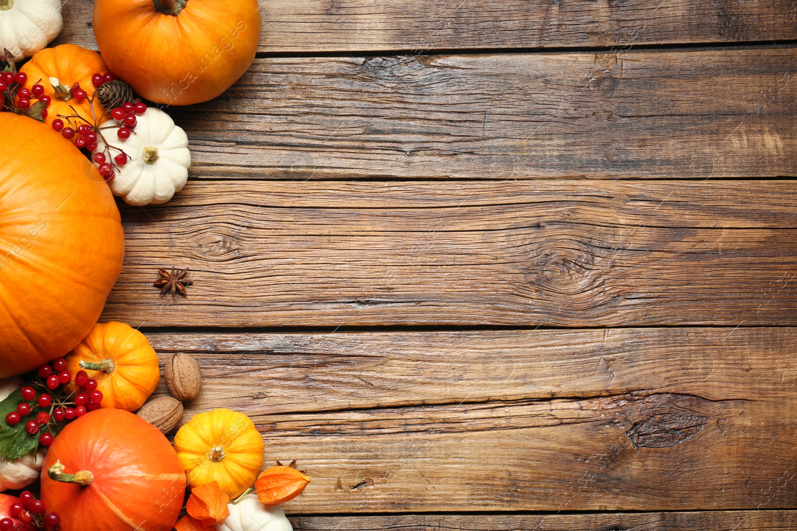 Photo of Thanksgiving day. Flat lay composition with pumpkins on wooden table, space for text