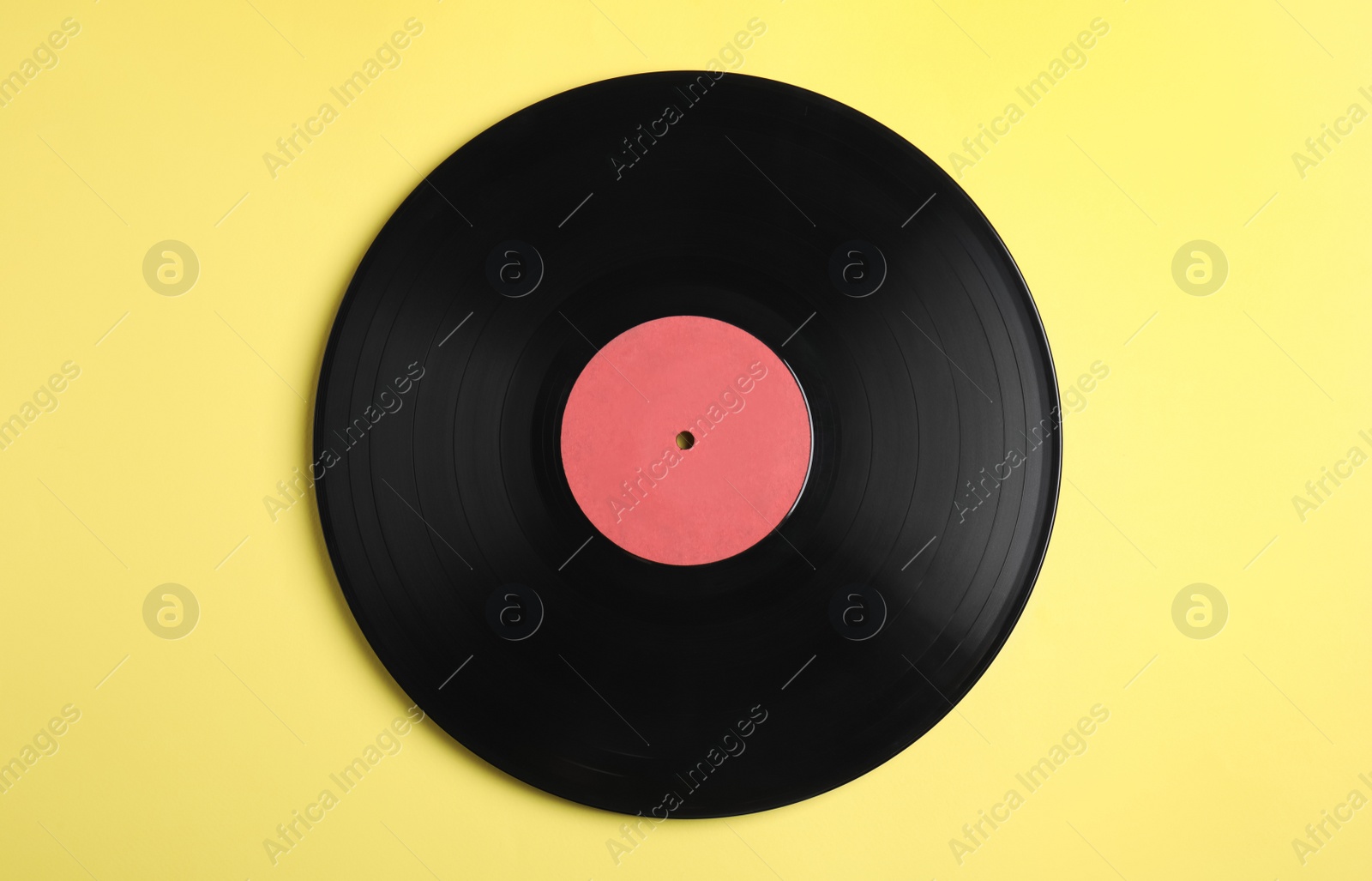 Photo of Vintage vinyl record on yellow background, top view