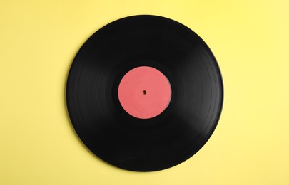 Photo of Vintage vinyl record on yellow background, top view