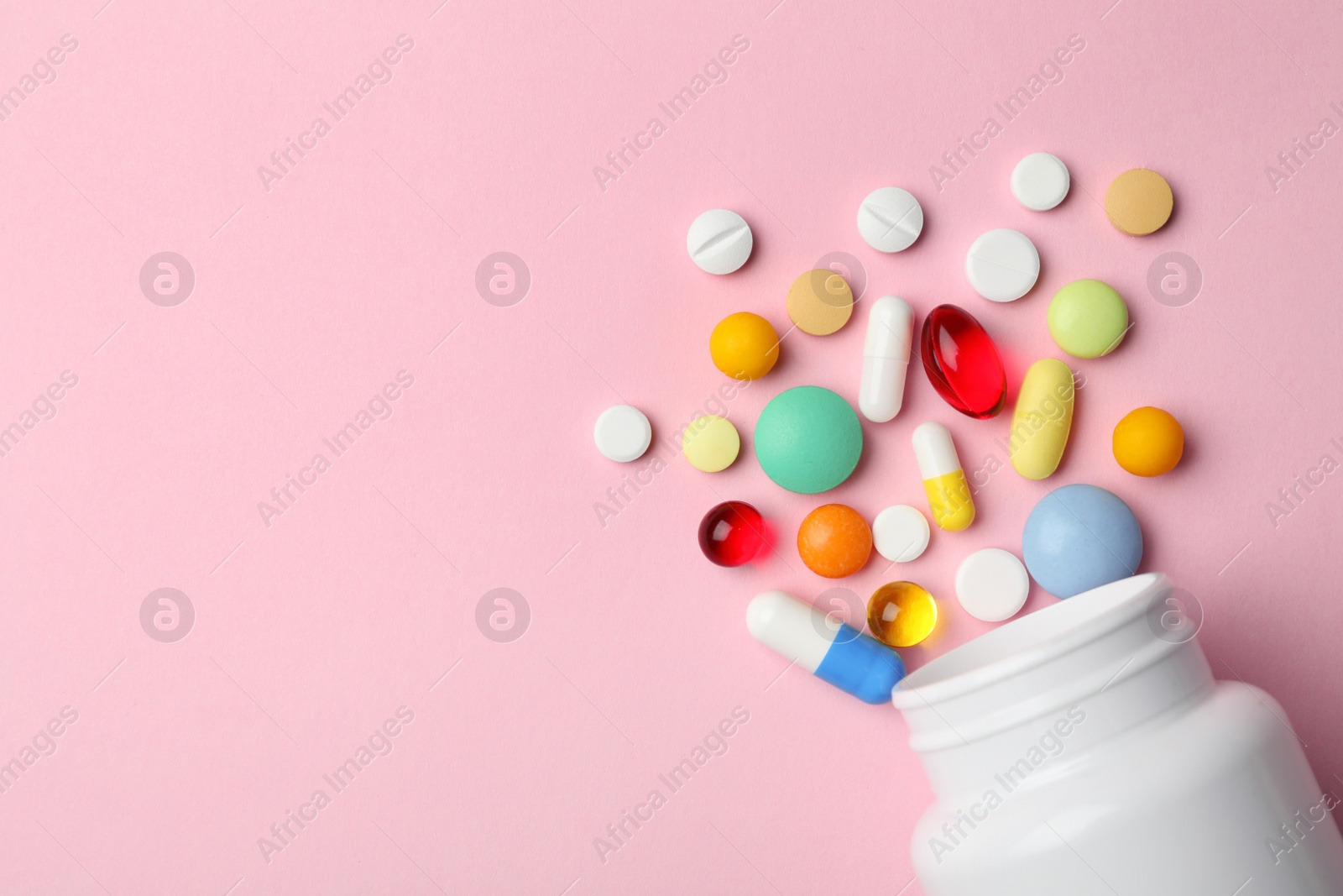 Photo of Bottle with different pills on color background, flat lay. Space for text