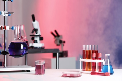 Photo of Different glassware with samples on table in chemistry laboratory