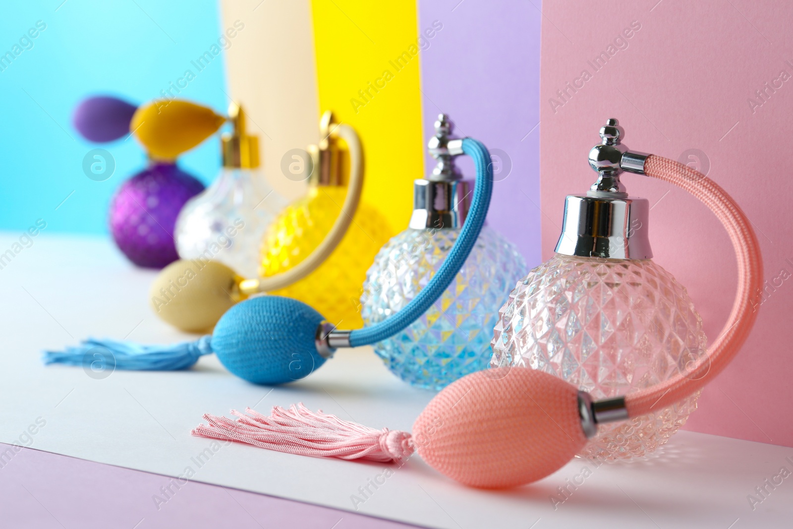 Photo of Composition with different bottles of perfume on color background, closeup