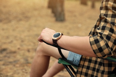 Photo of Man with stylish smart watch outdoors, closeup