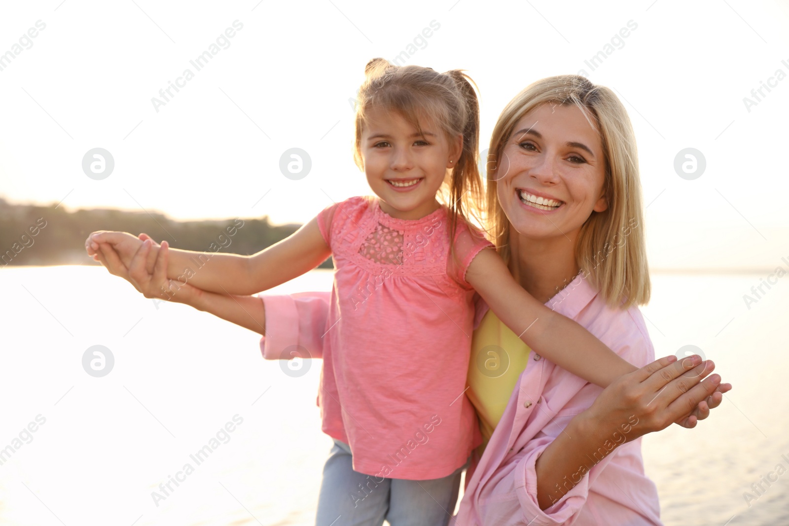 Photo of Happy mother and her child on beach. Spending time in nature