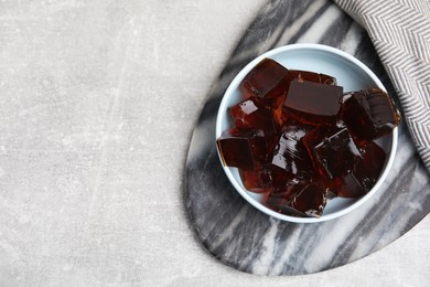 Photo of Delicious grass jelly cubes on light grey table, top view. Space for text