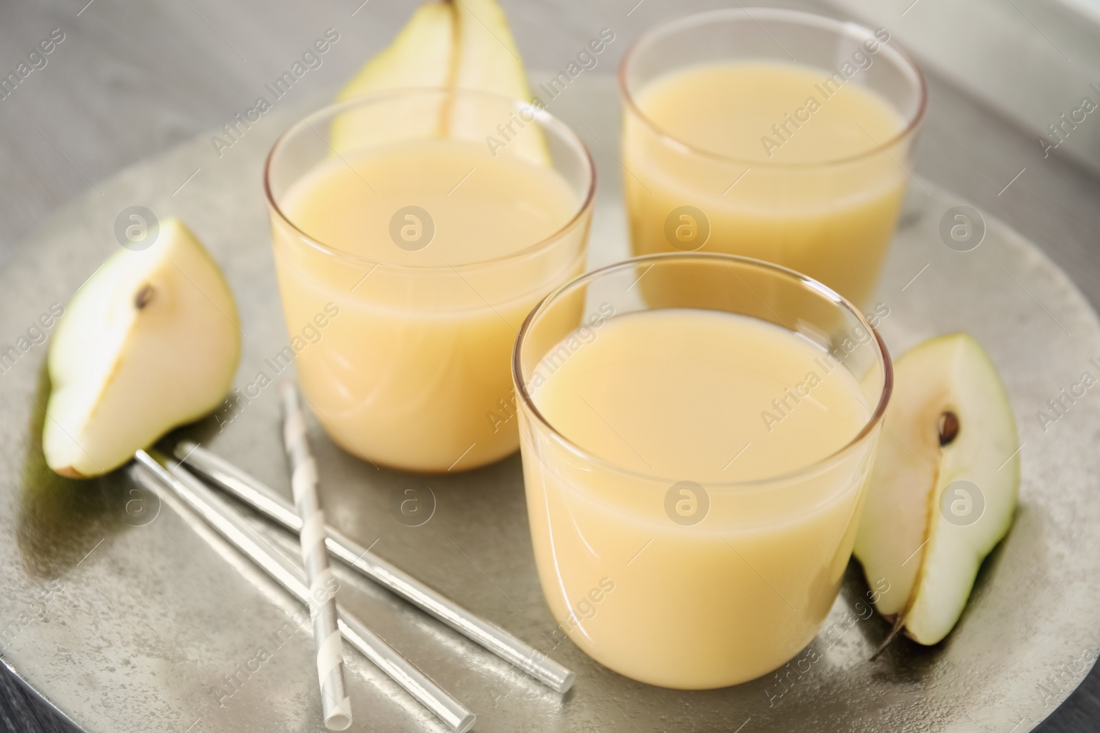 Photo of Tasty pear juice and cut fruit in plate, closeup